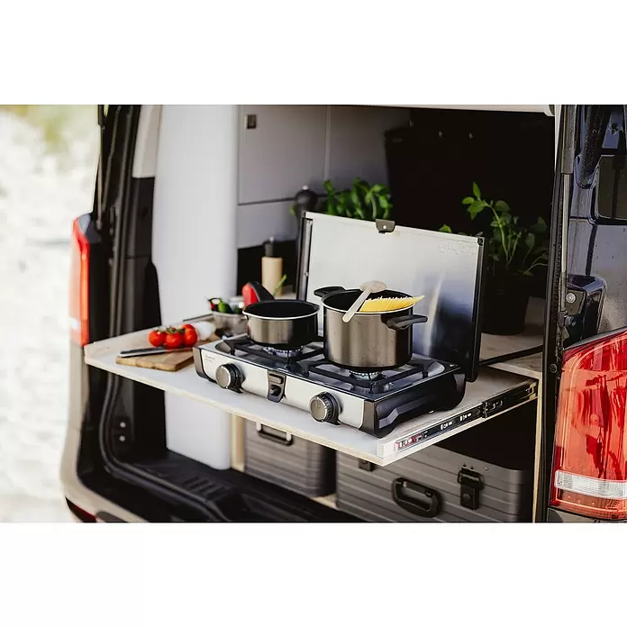 Enders Gaskocher Ryda 2Z - L x B x H: 32 x 52 x 9,5 cm, Edelstahl, 4,6 kW - Silberner und schwarzer Zweiflammen-Gaskocher mit Kochtöpfen, einer mit Pasta, in einem Campervan.