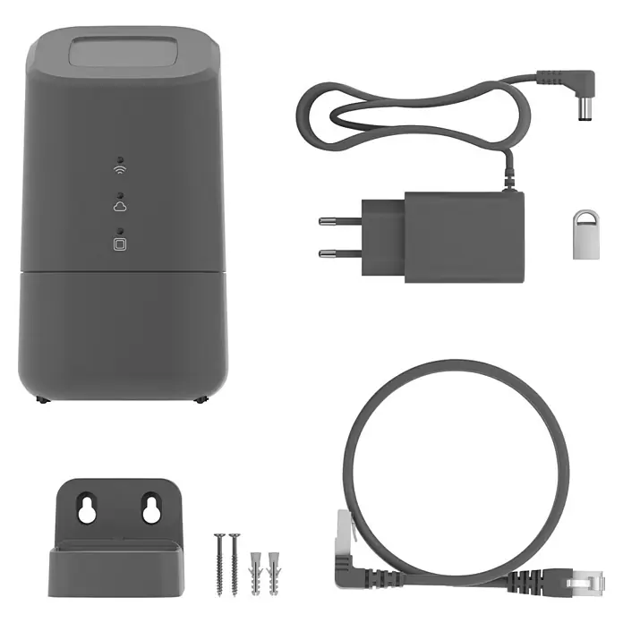 Homematic IP Steuerzentrale Home Control Unit HmIP-HCU1 - Anthrazit, L x B x H: 9,6 x 9,6 x 17,3 cm - Das Bild zeigt ein D-Link-Überwachungskit, inklusive Kamera, Netzteil, Ethernetkabel und Montagezubehör, alles in Grau auf schwarzem Hintergrund.