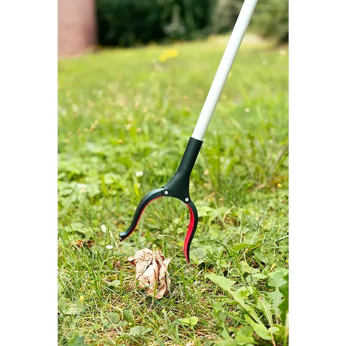 Greifer mit Magnet - Länge: 90 cm - Eine Müllgreifer-Zange hebt ein Stück Papier vom Rasen auf, ideal für die Gartenarbeit und zur Reinigung von Außenbereichen.
