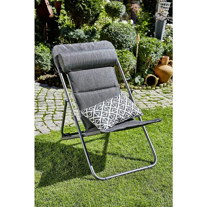 Sunfun Garten-Liegestuhl - Anthrazit, Klappbar - Grauer Gartenstuhl mit Kissen auf grünem Rasen. Der Stuhl hat ein modernes Design und lädt zum Entspannen im Freien ein.