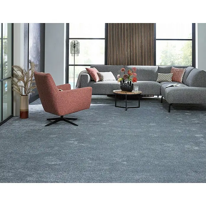 Teppichfliese Amazing - Hochflor, 100 % Polyester, Dunkelgrau - Einladender Wohnraum mit grauem Teppich, rotem Sessel und grauer Couch, ideal für gemütliche Stunden.