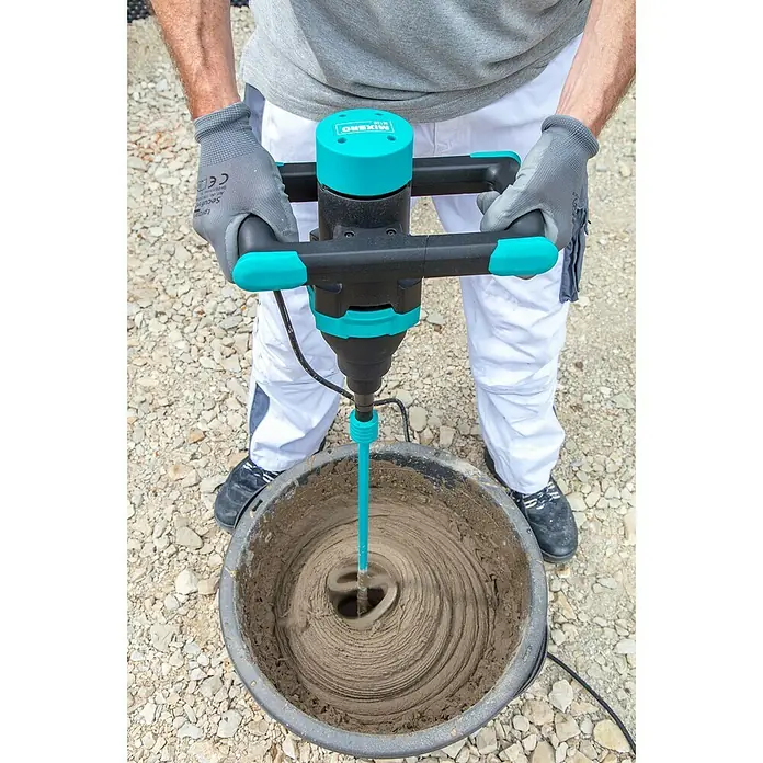 Collomix Mixbro Rührwerk M130 - Mischvolumen: 50 l, Gangzahl: 1 Stk. - Ein Arbeiter mischt Mörtel mit einem Mixerro Mörtelrührer in einem schwarzen Eimer. Der Mixerro ist blaugrün und schwarz.