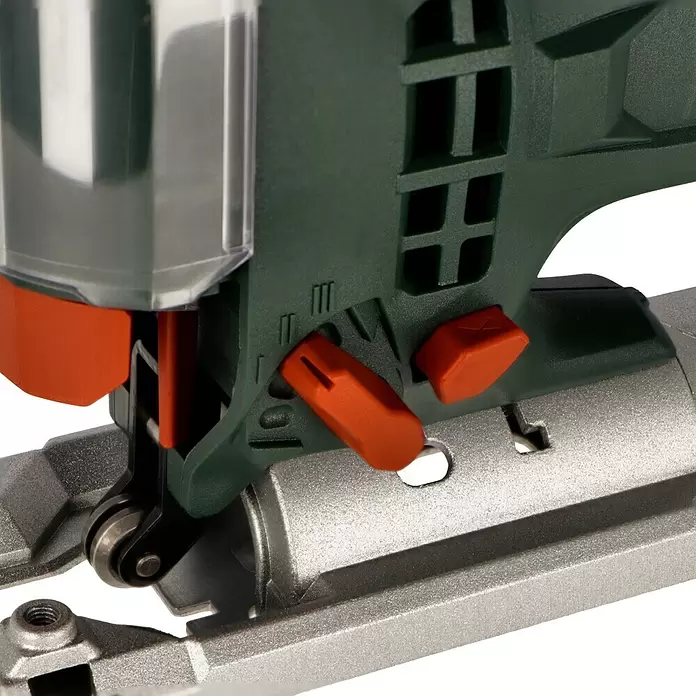 Metabo Caladora eléctrica STEB 100 Quick - 1.000 /min - 3.100 /min, Profundidad de corte máx. en madera: 100 mm, Número de niveles de elevación del péndulo: 4 ud. - Primer plano de la base metálica y los controles de acción orbital naranjas de una sierra de calar verde oscuro.