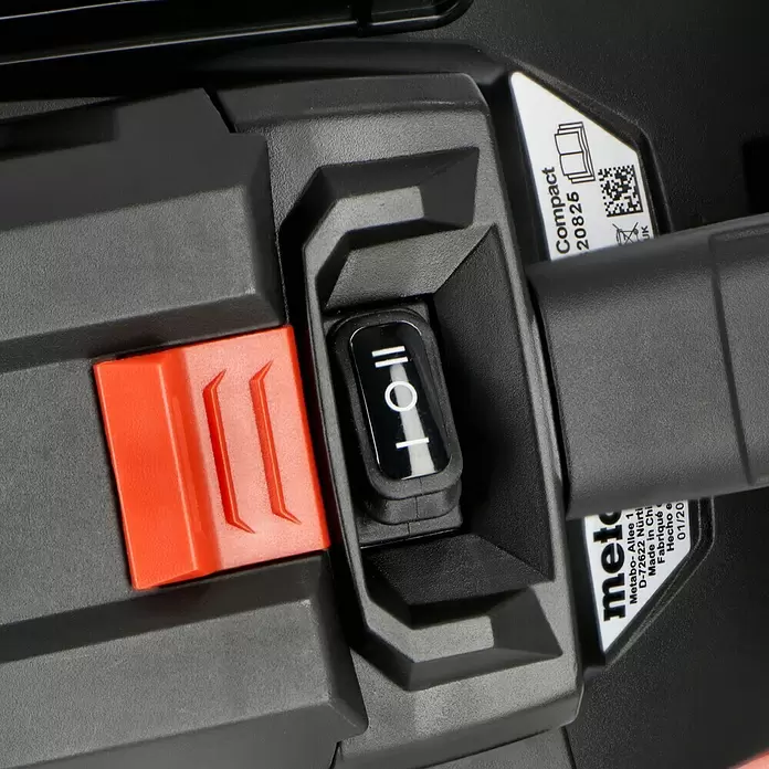 Metabo CAS 18V Akku-Nass-Trockensauger AS 18 HEPA PC Compact - 18 V, Ohne Akku, Behältervolumen: 6 l - Nahaufnahme eines schwarzen, strukturierten Elektrowerkzeugs mit rotem Sicherheitsschalter und schwarzem Kippschalter.