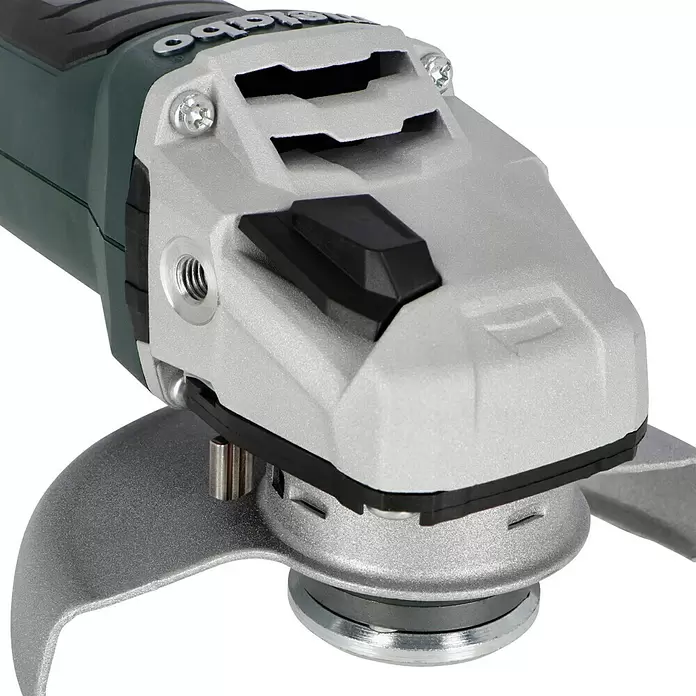 Metabo CAS 18V Amoladora angular de batería W 18 LT BL 11-125 - 18 V, 2 baterías, 4 Ah, Diámetro disco: 125 mm - Primer plano del cabezal gris plateado de una amoladora angular con botón de bloqueo del eje negro y protector.