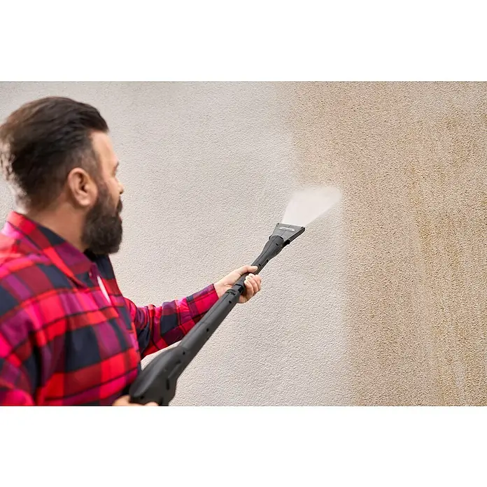Kärcher Strahlrohr eco!Booster 130 - Passend für: Kärcher Hochdruckreiniger der Klassen K4, 615 x 108 x 51 mm - Ein Mann benutzt einen Hochdruckreiniger, um eine Wand zu reinigen. Das Gerät entfernt Schmutz und sorgt für ein sauberes Ergebnis auf der Oberfläche.