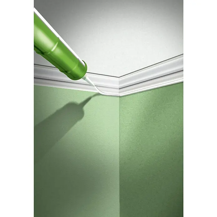 MEM Maleracryl - Transparent, 300 ml - Ein grüner Silikonpistole dichtet eine weiße Deckenleiste in einer Zimmerecke ab und sorgt für einen sauberen Übergang zwischen Wand und Decke.