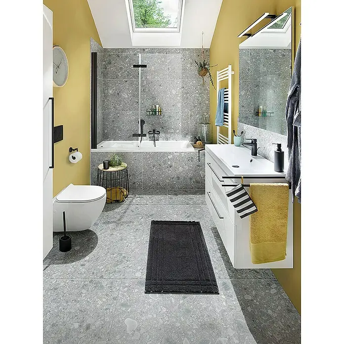 GEO Hit Pro Badewannenaufsatz B-PB400B x H: 140 x 150 cm, 2 Stk., Schwarz, DIN Anschlag: Rechts - Das Bild zeigt ein modernes Badezimmer mit grauen Fliesen, gelben Wänden und weißen Möbeln. Ein dunkler Badteppich liegt auf dem Boden.