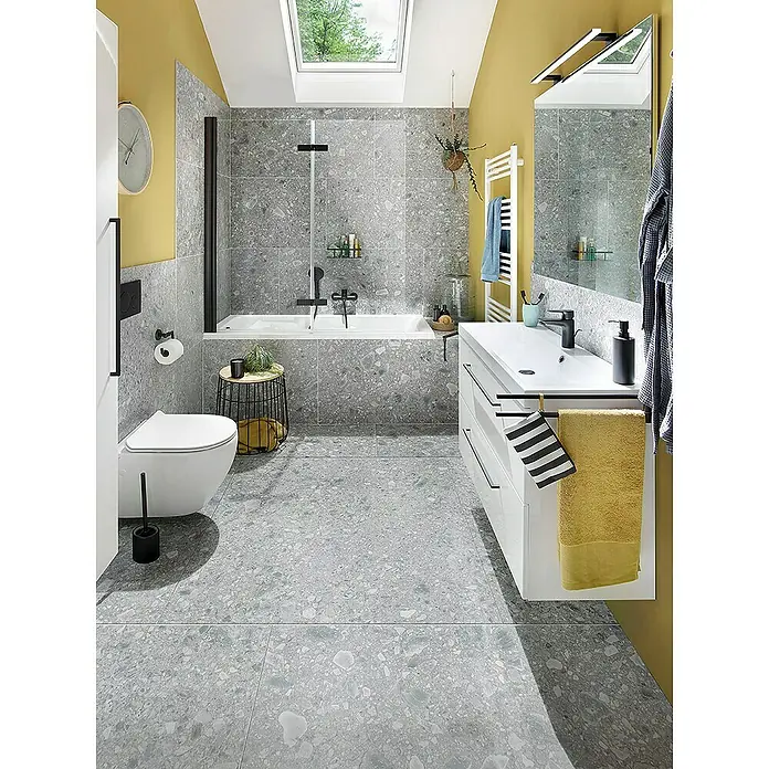 Camargue Badewanne Orlando - 160 x 70 cm, Sanitäracryl, Weiß - Helles Badezimmer mit grauen Fliesen, gelben Akzenten, einer Badewanne und einem Waschtisch mit Handtüchern für ein frisches Ambiente.