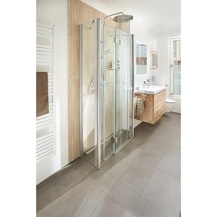 Camargue San Francisco Wand-WC-Set 2.0 - Spülrandlos, WC Abgang: Waagerecht, Weiß - Duschkabine mit klappbaren Glastüren in modernem Badezimmer. Das Bad ist mit hellem Holz und grauen Fliesen ausgestattet.