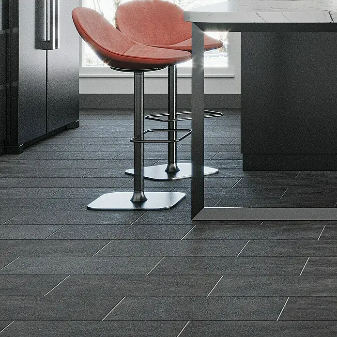 Domicil Feinsteinzeugfliese Living Concrete Urban - 30 x 60 cm, Anthrazit, Matt - Nahaufnahme von zwei roten Barhockern mit silbernen Beinen vor einer Kücheninsel mit dunklem Unterbau und Marmorplatte.