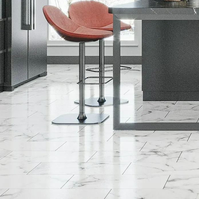 Feinsteinzeugfliese Prizma Statuario - 30 x 60 cm, Weiß/Grau, Glänzend - Detailaufnahme von zwei roten Barhockern mit Marmorboden und grauer Kücheninsel. Elegantes Küchendesign.