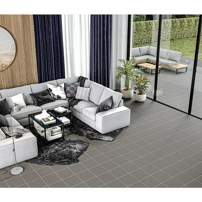 Feinsteinzeugfliese Saturn - 30 x 30 cm, Grau, Matt - Wohnzimmer mit grauem Ecksofa, Couchtisch und Pflanzen. Draußen ein Gartenset mit Sofa und Tischen auf der Terrasse.