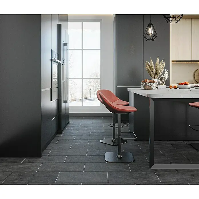 Domicil Feinsteinzeugfliese Living Concrete Urban - 30 x 60 cm, Anthrazit, Matt - Rote Barhocker aus Leder vor einer modernen Kücheninsel mit weißer Arbeitsplatte, ergänzen das stilvolle Küchendesign.