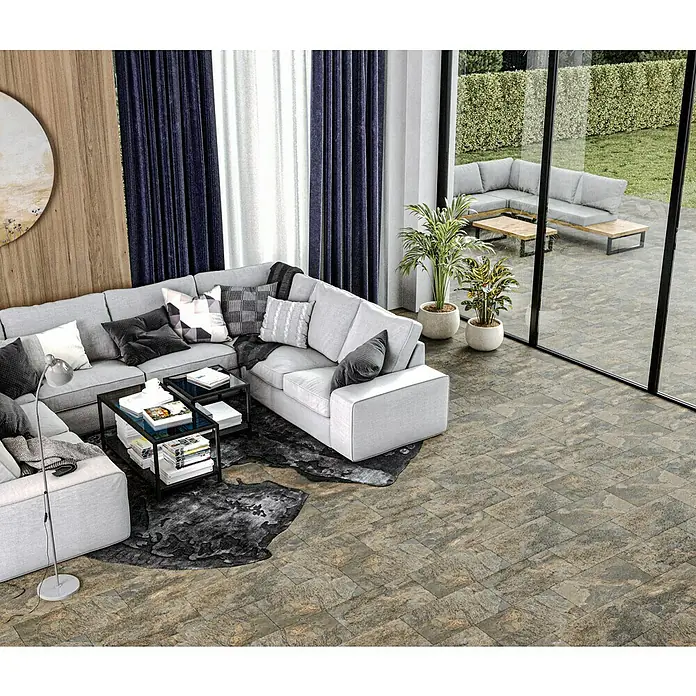 Decocer by Cinca Feinsteinzeugfliese Splash Grege - 30 x 60 cm, Braun, Matt - Elegantes Wohnzimmer mit großem Ecksofa, Couchtischen und Pflanzen. Die großen Fenster bieten einen schönen Ausblick auf den Garten.