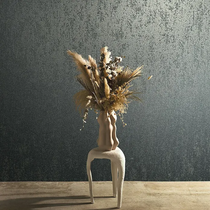 Marburg Eclectic Vliestapete Glasperlenstruktur - Blau, Metalloptik, 10,05 x 0,7 m - Elegantes Stillleben mit Trockenblumen in einer skulpturalen Vase auf einem weißen Hocker vor einer strukturierten Wand.
