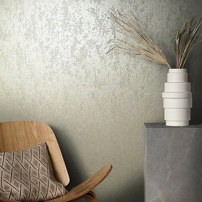 Marburg Eclectic Vliestapete Glasperlenstruktur - Dunkelbeige, Metalloptik, 10,05 x 0,7 m - Nahaufnahme einer strukturierten Tapete in neutralen Tönen, kombiniert mit einem Holzstuhl und einer dekorativen Vase.