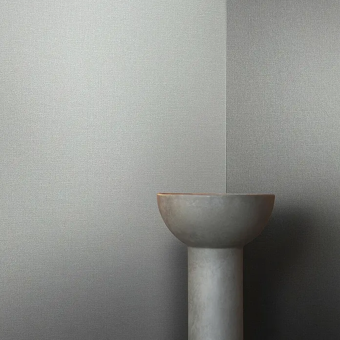 Marburg Eclectic Vliestapete - Lichtgrau, Uni, 10,05 x 0,7 m - Ein minimalistisches Podest in sanften Grautönen vor einer strukturierten Wand, ideal für Produktpräsentationen und künstlerische Inszenierungen.