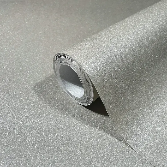 Marburg Eclectic Vliestapete - Grau, Metalloptik, 10,05 x 0,7 m - Nahaufnahme einer Rolle silberner Glitzertapete. Die Textur der Tapete reflektiert sanft das Licht und verleiht jedem Raum einen Hauch von Eleganz.
