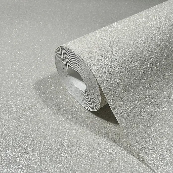 Marburg Eclectic Vliestapete - Sandbeige, Uni, 10,05 x 0,7 m - Nahaufnahme einer Rolle glitzernder, silberner Tapete, die Textur und Reflexion des Materials hervorhebt, perfekt für moderne Interieurs.
