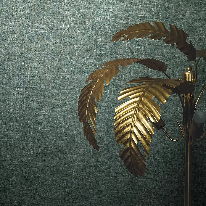 Marburg Eclectic Vliestapete - Blau, Uni, 10,05 x 0,7 m - Nahaufnahme einer stilvollen goldenen Palmenlampe vor einem strukturierten, blaugrünen Hintergrund. Elegantes Wohnaccessoire für ein gemütliches Ambiente.