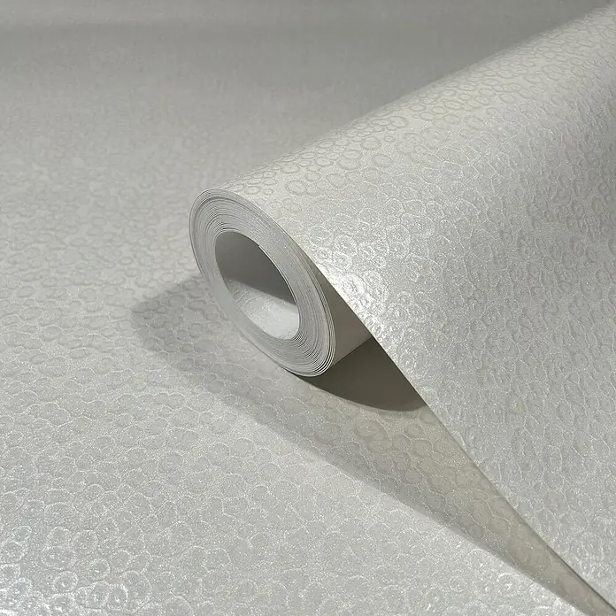 Marburg Eclectic Vliestapete Hammerschlag-Optik - Weiß, Metalloptik, 10,05 x 0,7 m - Nahaufnahme einer Rolle weißer Tapete mit einem subtilen, sich wiederholenden Muster, ideal für eine elegante Wandgestaltung.