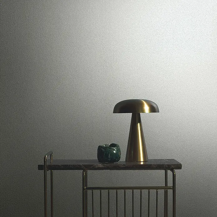 Marburg Eclectic Vliestapete - Sandbeige, Uni, 10,05 x 0,7 m - Nahaufnahme einer Tischleuchte und einer grünen Dekoration auf einem goldenen Beistelltisch vor einem neutralen Hintergrund.