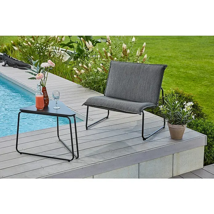 Sunfun Loungemöbel-Set Sarah - 2 -tlg., Stahl/Textilgewebe, Anthrazit - Grauer Loungesessel und dreieckiger Beistelltisch aus Metall neben dem Pool, dekoriert mit Blumen, einem Getränk und einem Weinglas.