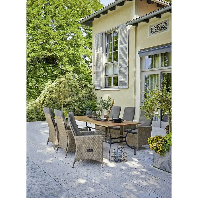 Sunfun Moni Gartentisch - L x B x H: 220 x 100 x 77 cm, Akazie, Stahl, Rechteckig, Natur, Schwarz - Ein einladender Außenbereich mit einem eleganten Esstisch-Set aus Holz und Rattanmöbeln auf einer stilvollen Terrasse.