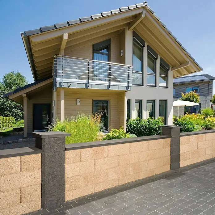 EHL Mauerabdeckung - 50 x 32 x 4 cm, Anthrazit, Beton - Ansicht eines Hauses mit einer attraktiven Blocksteinmauer und einem Gehweg. Die Mauer besteht aus braunem Stein mit grauen Säulen und Abdeckplatten.
