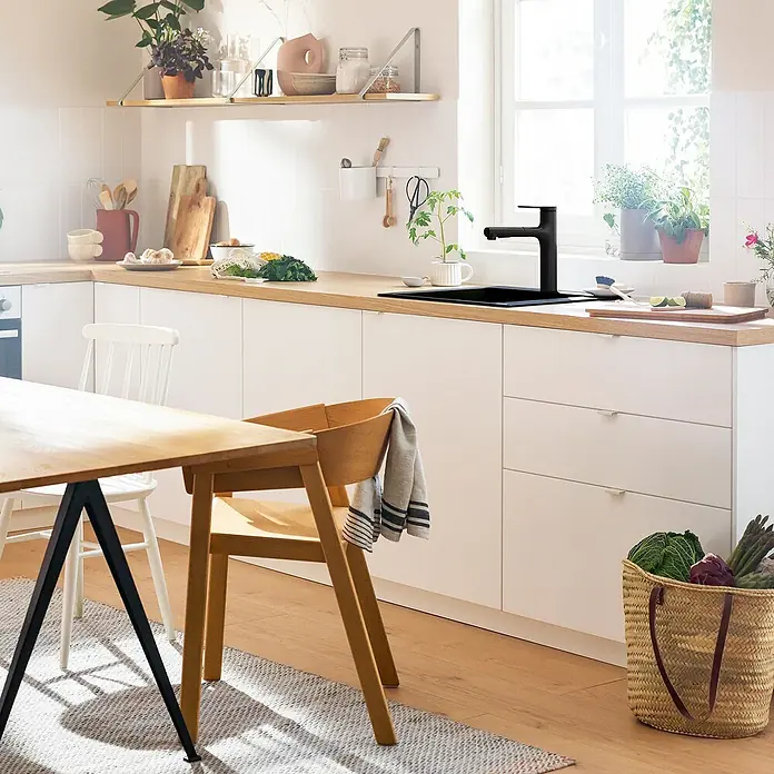 Hansgrohe Zesis M33 Spültischarmatur - Mattschwarz, Matt, Ohne sBox - Küchenszene mit schwarzer Spüle und Armatur, die modernes Design und Funktionalität vereinen. Helle Farben und natürliche Elemente ergänzen das Bild.