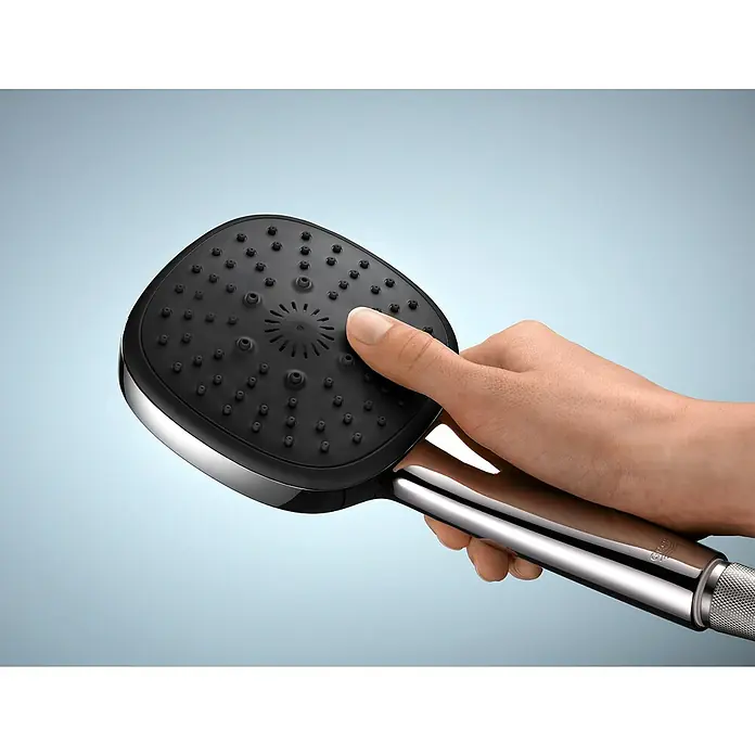 Grohe QuickFix Handbrause - Durchmesser: 11 cm, Anzahl Strahlarten: 2 Stk. - Handbrause aus Chrom und Schwarz, gehalten von einer Hand vor einem blauen Hintergrund.