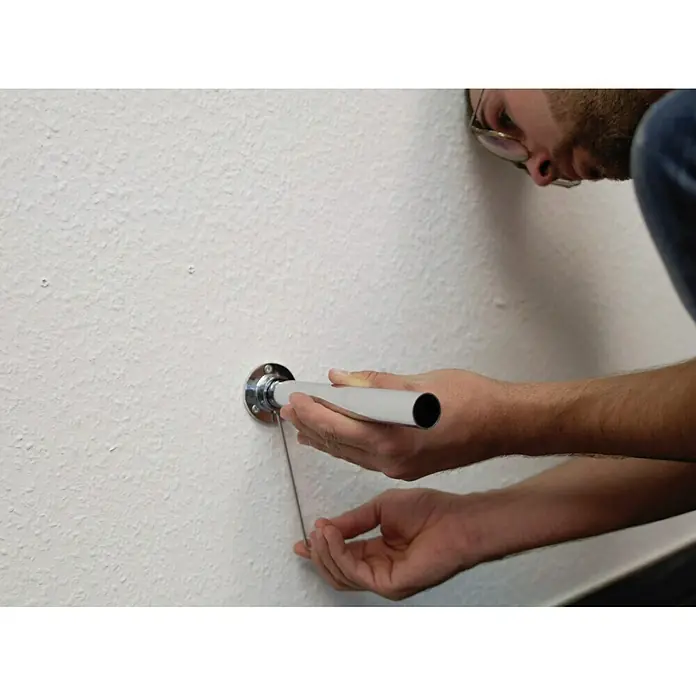 Easy Connect Regalsystem-Grundmodul - Passend für: 3 Regalböden - Eine Person befestigt eine silberne Stange an einer Wandhalterung. Der Handwerker installiert das Produkt fachmännisch an der Wand.