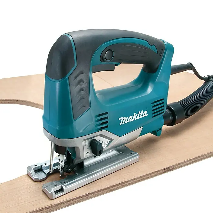 Makita Sierra de calar eléctrica JV0600K - 500 /min - 3.100 /min, 90 mm - Sierra de calar Makita turquesa y negra sobre una tabla de madera. Ideal para cortes precisos de madera y materiales.