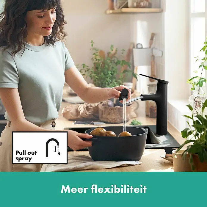 Hansgrohe Zesis M33 Spültischarmatur - Mattschwarz, Matt, Ohne sBox - Eine Frau wäscht Kartoffeln mit einer schwarzen Küchenarmatur mit Ausziehbrause. Das moderne Design bietet Flexibilität in der Küche.