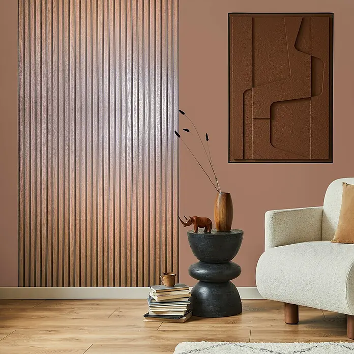 Marburg Travertino Vliestapete Paneel-Optik - Kupfer, Metalloptik, 10,05 x 0,53 m - Elegantes Wohnzimmer mit geriffelter Akzentwand, abstraktem Kunstwerk und stilvollem Beistelltisch.