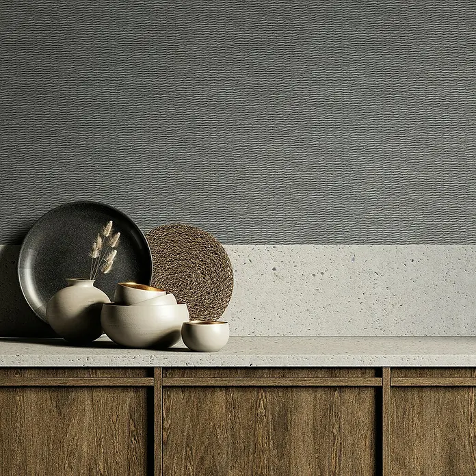 Marburg Travertino Vliestapete Textiloptik - Grau, Sonstiges, 10,05 x 0,53 m - Keramikgeschirr-Set in neutralen Tönen, bestehend aus Teller, Schalen und Vase, arrangiert auf einer Küchentheke aus Holz und Stein.