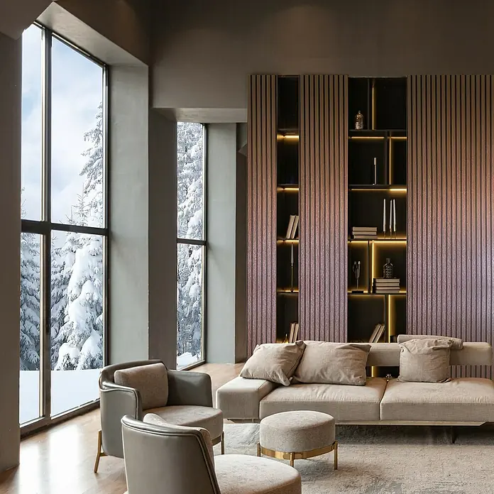 Marburg Travertino Vliestapete Paneel-Optik - Kupfer, Metalloptik, 10,05 x 0,53 m - Elegantes Wohnzimmer mit beigefarbenem Sofa, Sesseln und Bücherregal vor einer verschneiten Landschaft. Moderner Stil mit viel Licht.