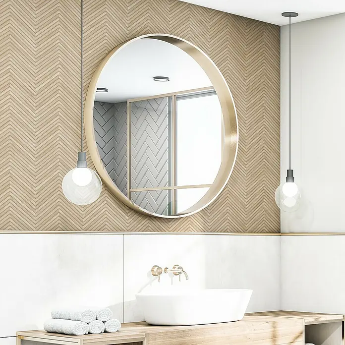 Marburg Travertino Vliestapete Fischgrätmuster - Beige, Holzoptik, 10,05 x 0,53 m - Badezimmerdesign mit rundem Spiegel, hölzernem Fischgrätmuster, weißen Armaturen und zwei stilvollen Hängelampen für ein modernes Ambiente.