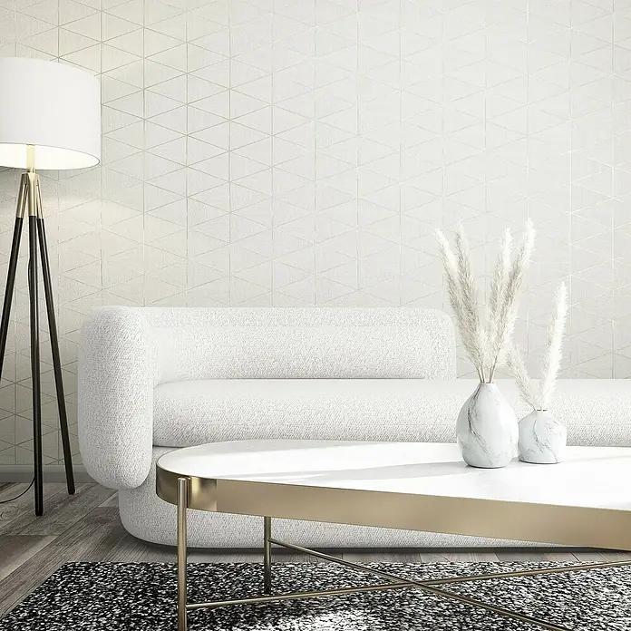 Marburg Travertino Papiertapete - Weiß, Grafisch, 10,05 x 0,53 m - Elegantes Wohnzimmer-Interieur mit weißem Sofa, Marmorvasen und goldenem Couchtisch auf einem stilvollen Teppich. Die Stehlampe rundet das Ambiente ab.