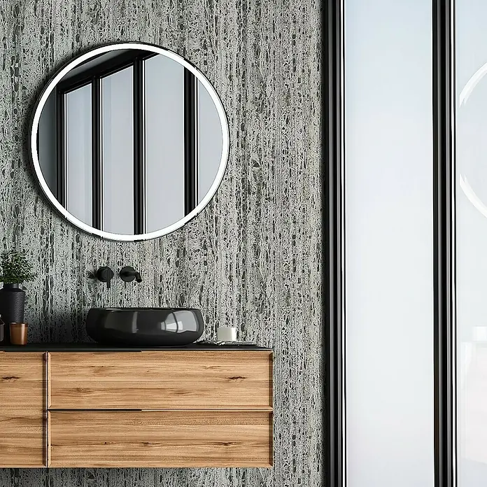 Marburg Travertino Vliestapete Struktur - Greige-Grau, Steinoptik, 10,05 x 0,53 m - Modernes Badezimmer-Interieur mit einem runden Spiegel mit Hintergrundbeleuchtung über einem Holzwaschtisch mit schwarzem Waschbecken.