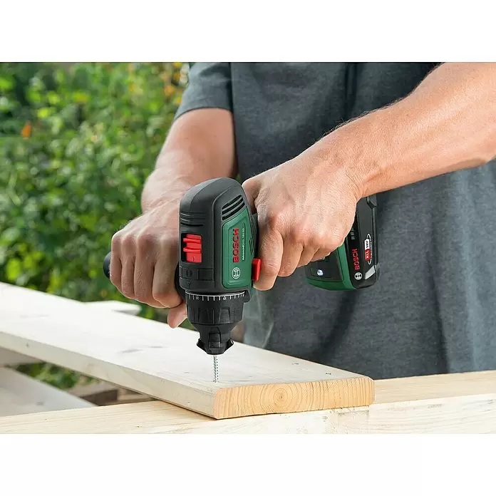 Bosch Power for All 18V Taladro atornillador de batería AdvancedDrill 18V-80 - 18 V, 2 baterías, 2,5 Ah, 78 Nm - Persona usa taladro atornillador Bosch negro y verde para atornillar un tornillo en tabla de madera al aire libre.