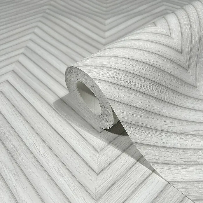 Marburg Travertino Vliestapete Fischgrätmuster - Weißgrau, Holzoptik, 10,05 x 0,53 m - Nahaufnahme einer Rolle grauer Chevron-Tapete mit einem subtilen Holzmaserungseffekt, ideal für moderne Innenräume.