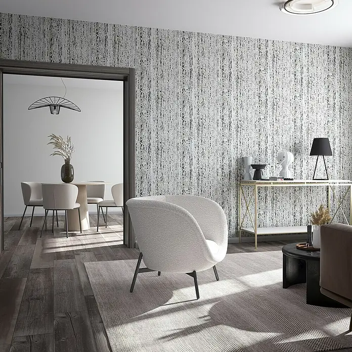 Marburg Travertino Vliestapete Struktur - Hellgrau-Grau, Steinoptik, 10,05 x 0,53 m - Elegantes Wohnzimmer mit modernem Sessel, stilvollem Konsolentisch und einer auffälligen Tapete in Grau- und Weißtönen.