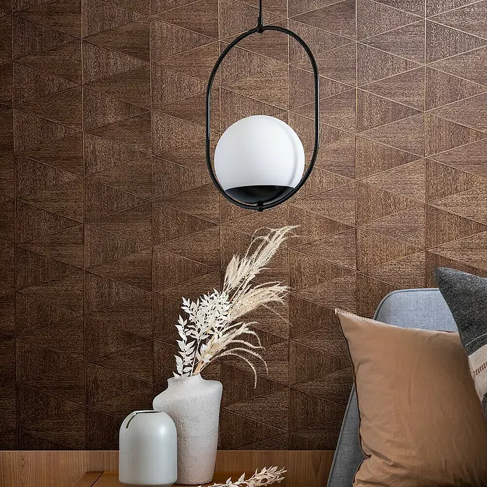 Marburg Travertino Papiertapete - Braun, Grafisch, 10,05 x 0,53 m - Elegante Hängeleuchte mit kugelförmigem Lampenschirm vor einer strukturierten Wand. Dekorative Vasen und Kissen ergänzen das stilvolle Interieur.