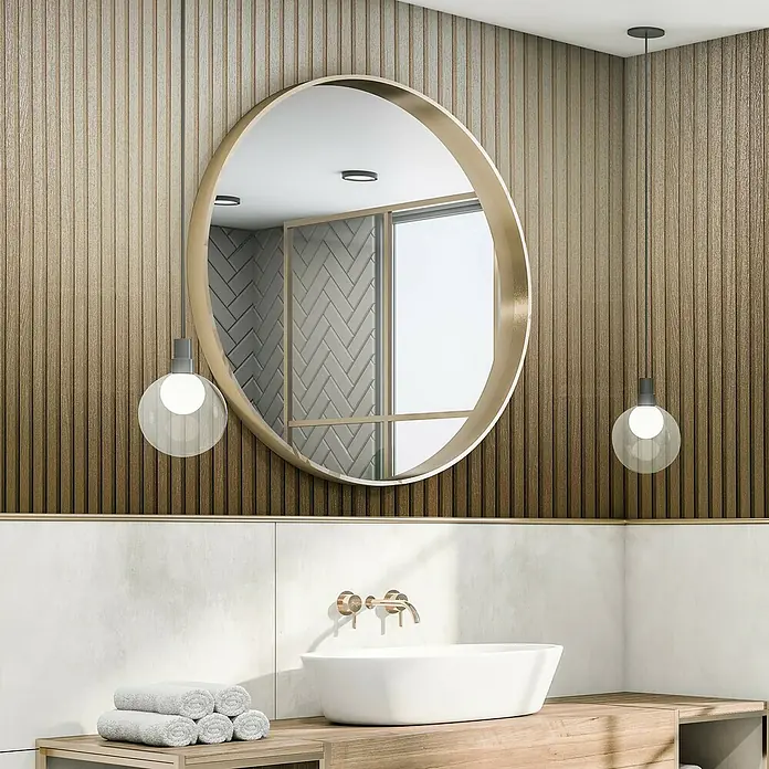Marburg Travertino Vliestapete Paneel-Optik - Gold, Metalloptik, 10,05 x 0,53 m - Helles Badezimmer mit einem runden Spiegel über einem stilvollen Waschbecken und Holzelementen, die eine ruhige Atmosphäre schaffen.