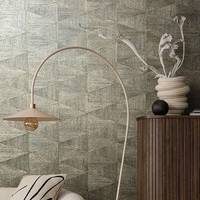 Marburg Travertino Papiertapete - Braungrau, Grafisch, 10 x 0,53 m - Nahaufnahme einer stilvollen Stehlampe vor einer Wand mit dreieckigem Fliesenmuster.