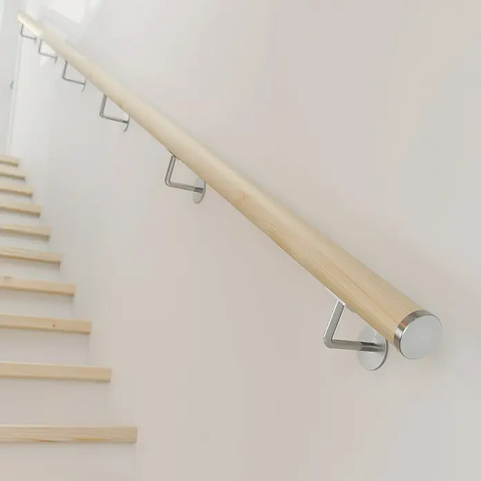Dolle Handlauf PS 3/40 - Fichte Natur, Unbehandelt, Rund, Länge: 200 cm - Detailansicht eines Holzhandlaufs mit silbernen Halterungen an einer hellen Wand entlang einer Treppe.