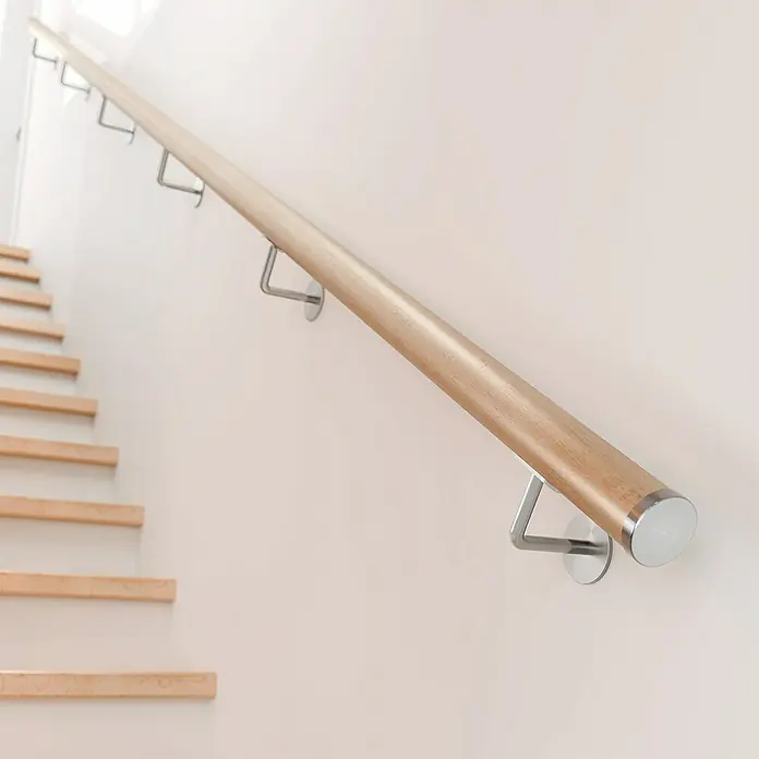 Dolle Handlauf PS 3/50 - Buche Natur, Lackiert, Rund, Länge: 200 cm - Diese Aufnahme zeigt ein Holzhandlauf mit modernen Metallstützen an einer hellen Wand entlang einer Holztreppe.