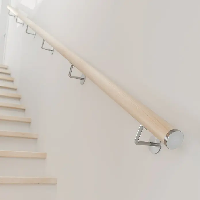 Dolle Handlauf PS 3/50 - Ahorn Natur, Lackiert, Rund, Länge: 200 cm - Detailaufnahme eines hölzernen Treppengeländers mit Metallhalterungen an einer weißen Wand, das Design und die Funktionalität vereint.